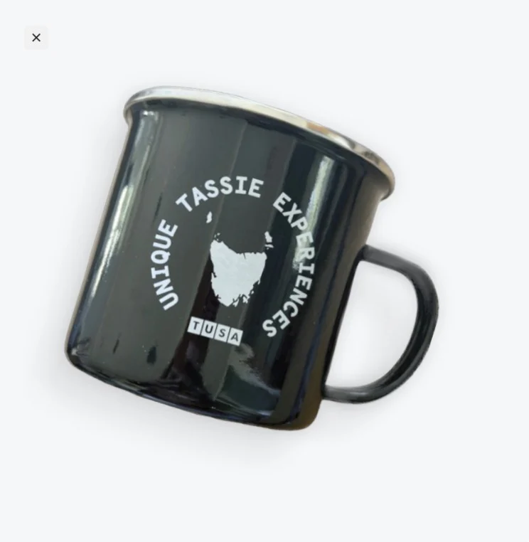 Black metal mug with "UNIQUE TASSIE EXPERIENCE" and an outline of Tasmania printed in white on the side.