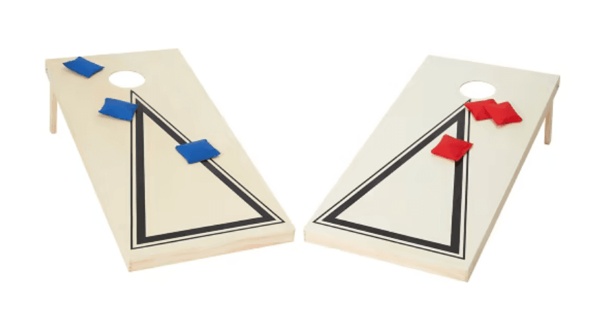 Two cornhole boards with triangle designs, one with blue bean bags and the other with red bean bags placed on top.