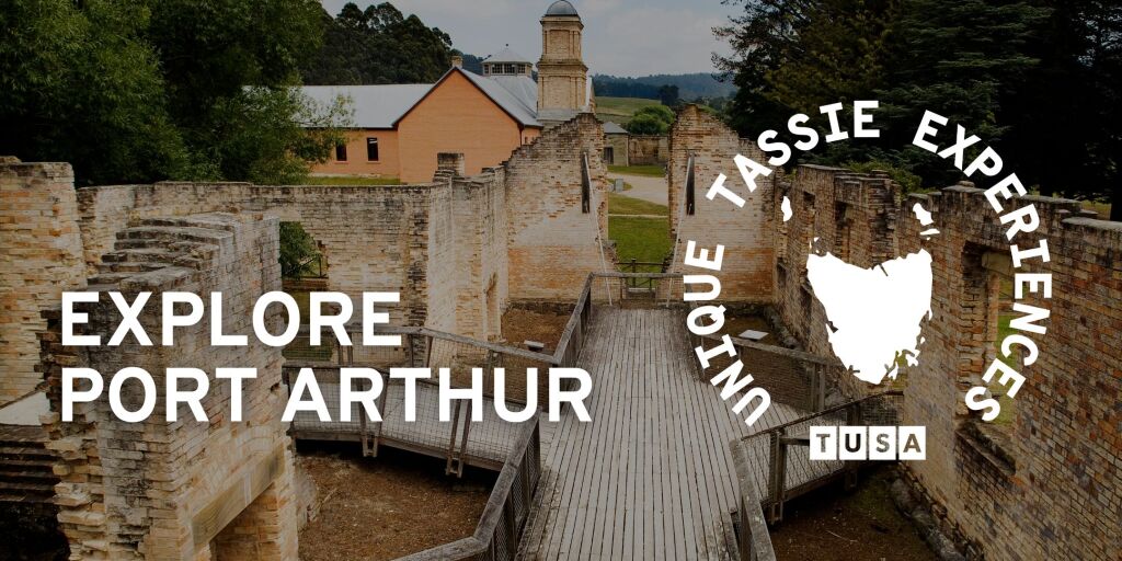 Ruins of historic stone buildings with wooden walkways at Port Arthur, Tasmania, surrounded by trees and featuring promotional text about unique experiences.